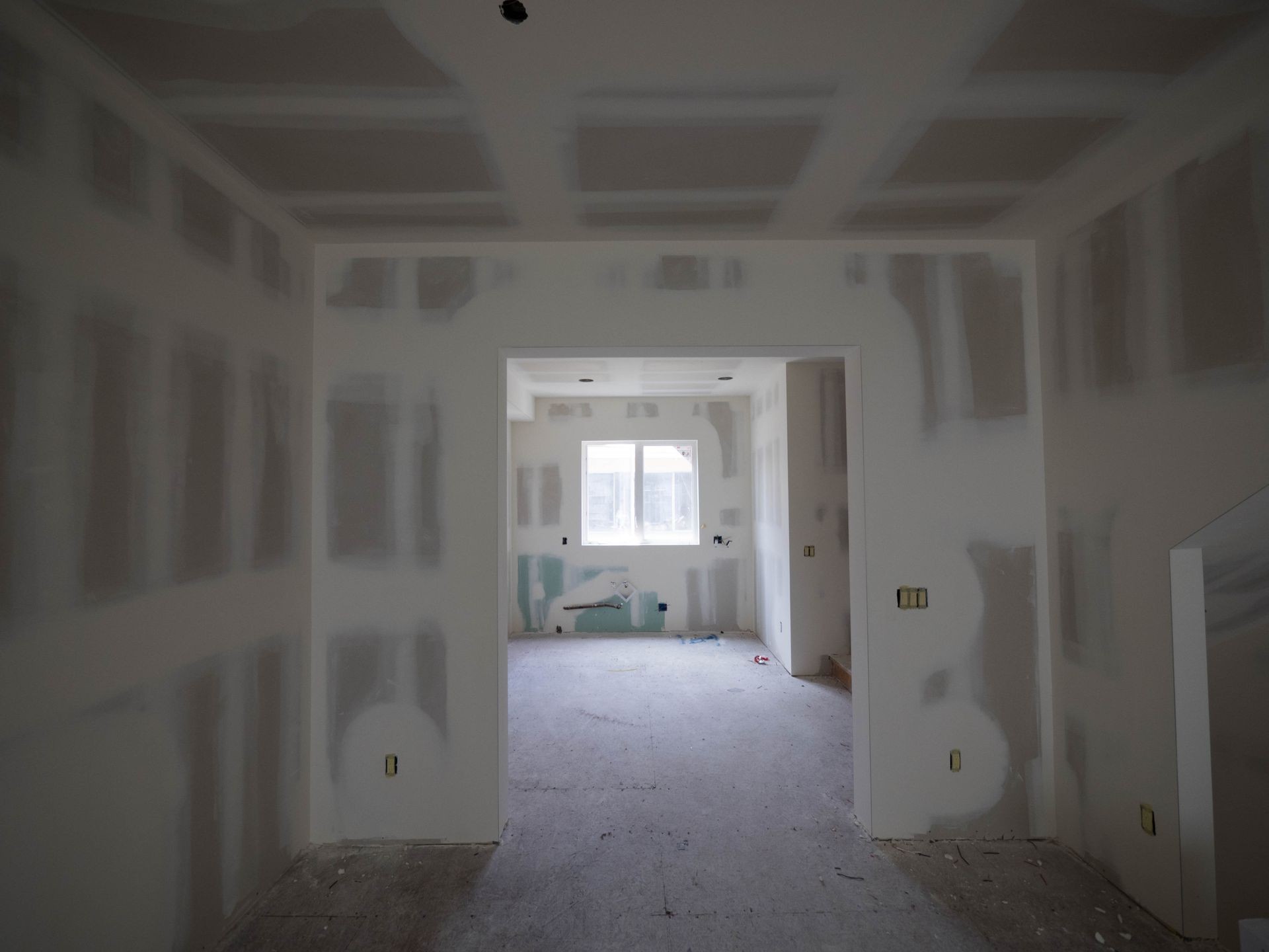 Interior construction of housing project with drywall installed and patched without painting applied